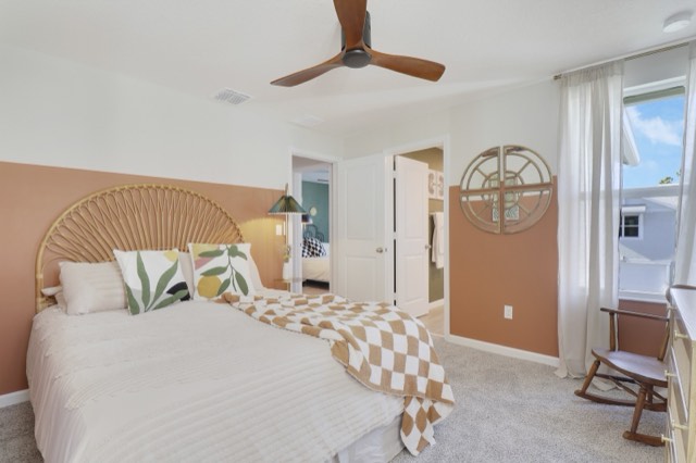 Coral and cream bedroom with a rattan headboard; two doorways side by side, one to the hall and one into an olive-walled bath