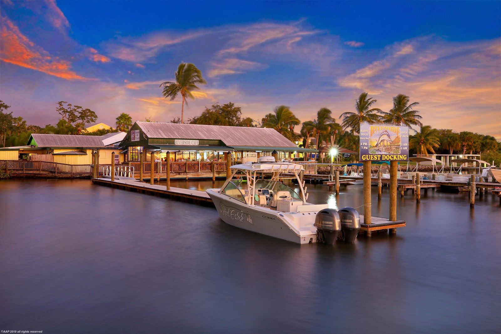 Riverside Cafe at dusk, its docks on the Indian River with a boat tied up at guest docking, Vero Beach